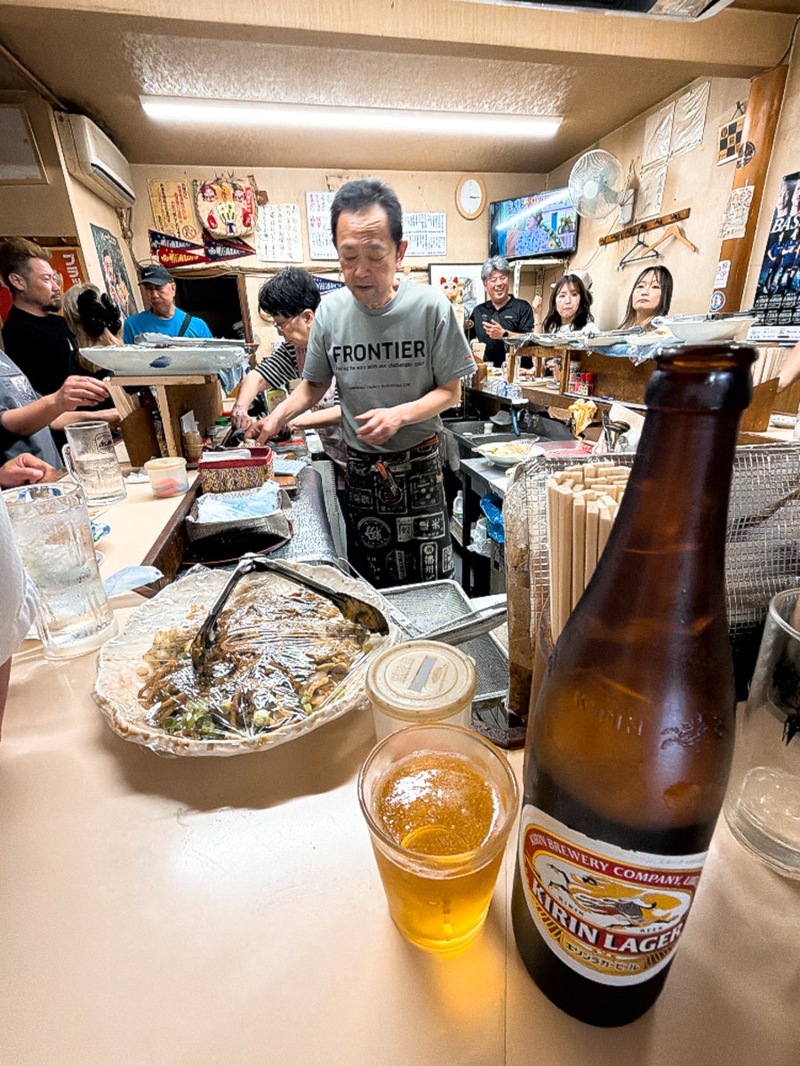 立呑み処 呑べえ 明石 店内 コの字カウンター 大将 常連客 キリンラガー大瓶 立ち飲み 壁にお品書き
