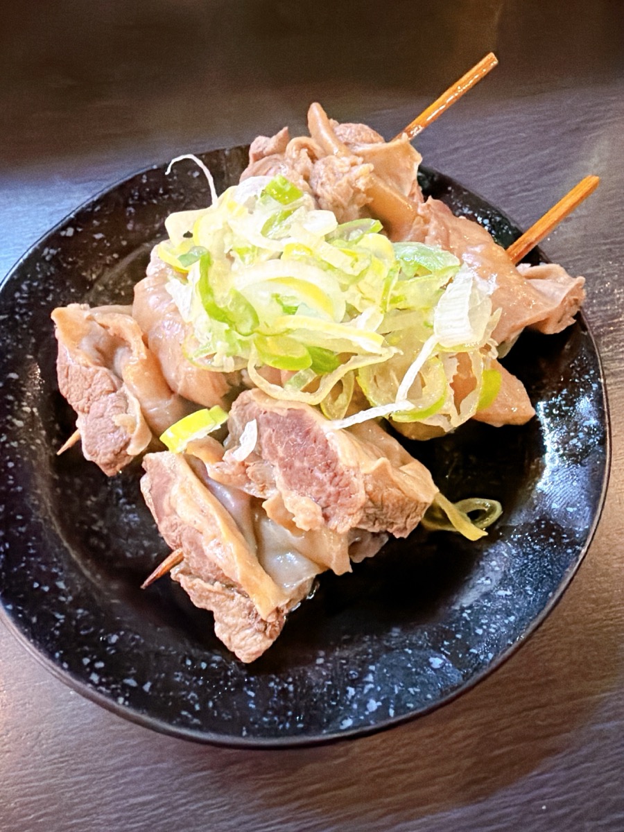 もつ焼き 独歩 天満店 もつ焼き串 白ねぎ ねぎだれ 黒い丸皿 葱たっぷり 串2本