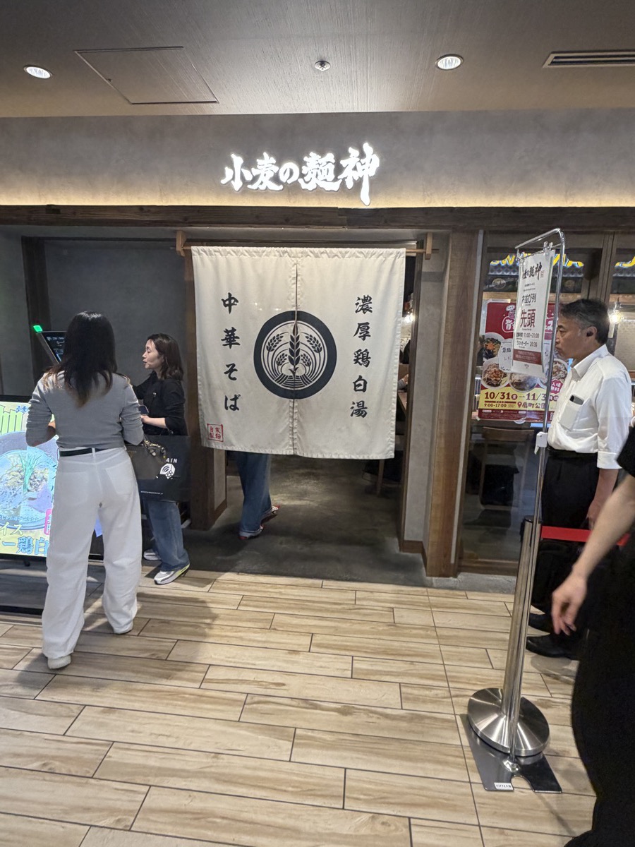 小麦の麺神 KITTE大阪店 外観 白い暖簾 濃厚鶏白湯 中華そば ロゴ看板